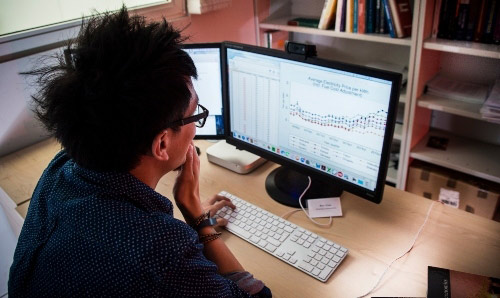 A man looking at a graph on a computer screen